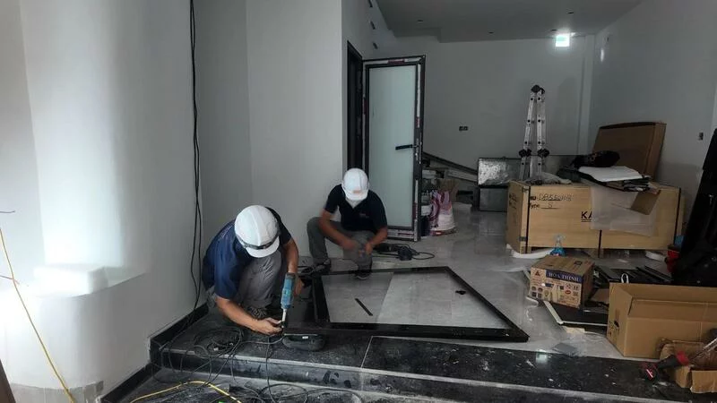 Đội ngũ kỹ thuật viên chuẩn bị và làm đế pít tại vị trí lắp đặt thang.