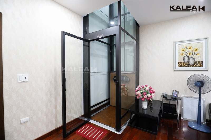 Thang máy được bố trí gọn trong góc phòng, sát tường và cạnh khu vực sinh hoạt, giúp tận dụng phần diện tích trống mà không cản trở lối đi chính.