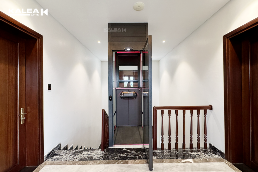 Thang máy kính sàn nâng Kalea X50 lắp đặt giữa thang bộ giúp tối ưu diện tích