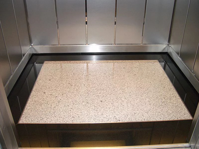 Sàn thang máy làm từ chất liệu Granite kết hợp với viền đá đen sang trọng
